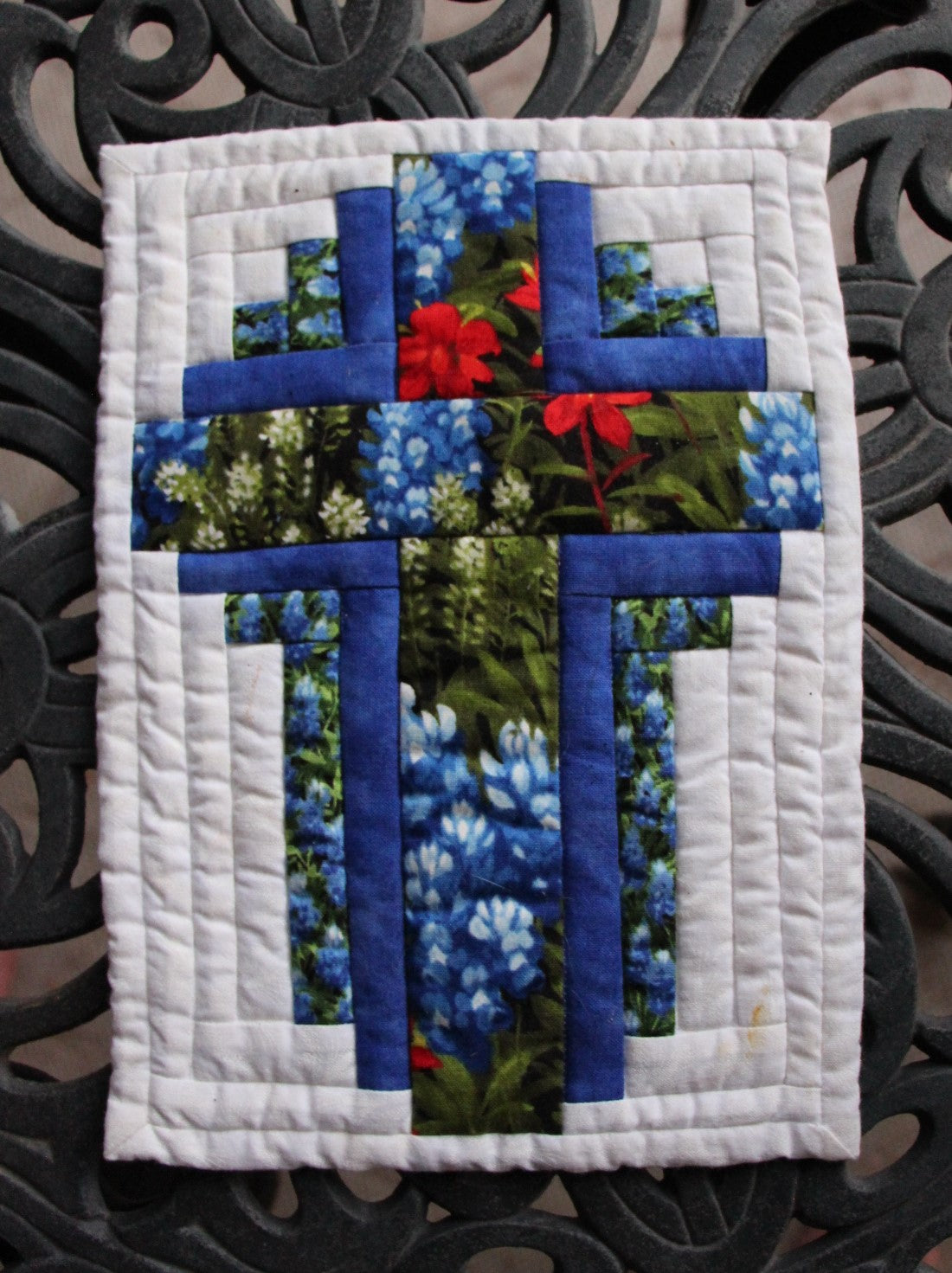 Cross mug rug quilt pattern using bluebonnet fabric and dark blue marble fabric with a white background.