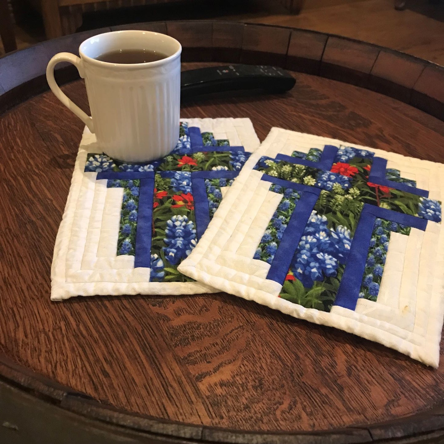 Cross mug rug using log cabin block design shown on a table.